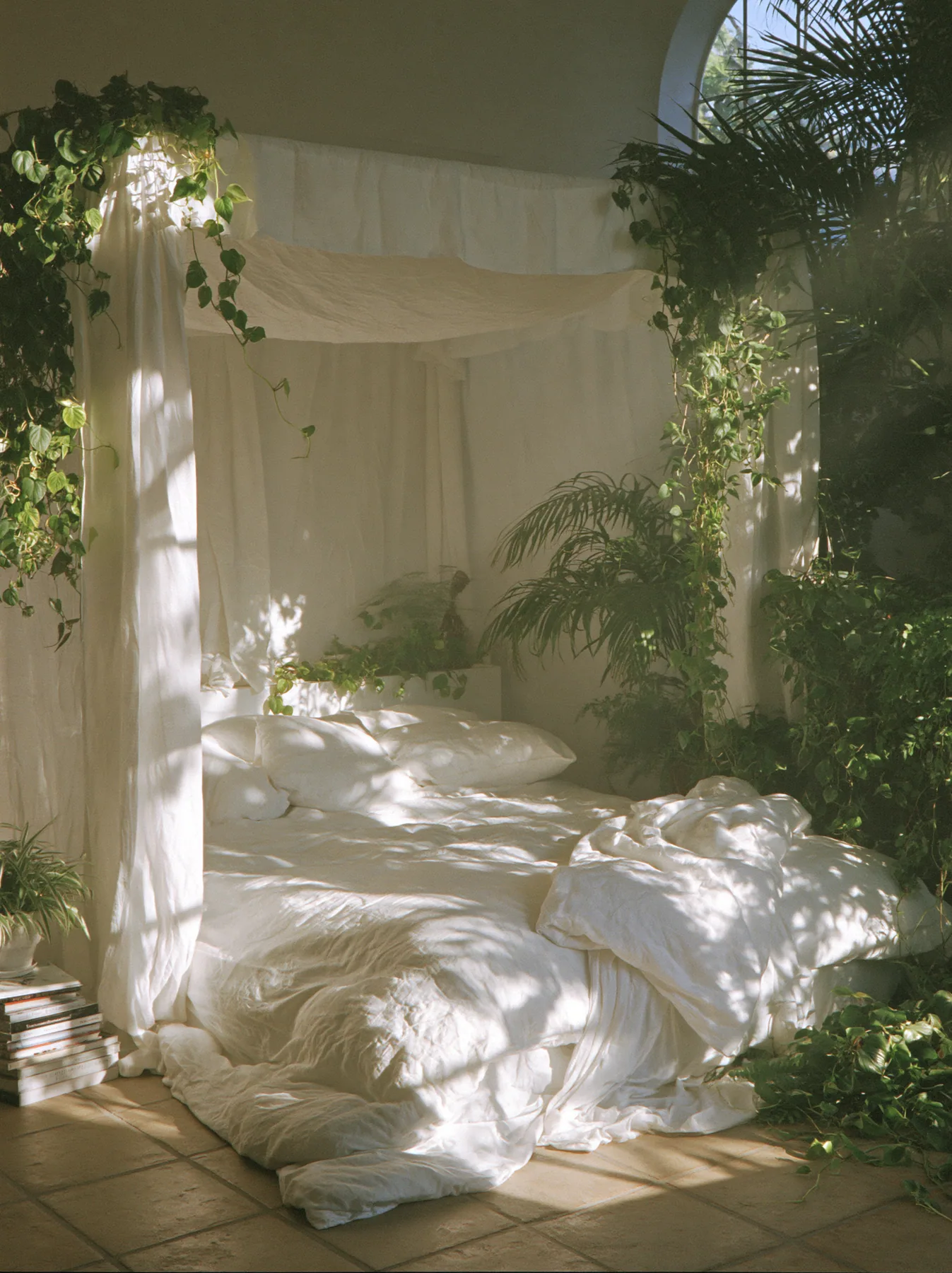 a dreamy bedroom with a linen canopy bed and trailing plants, soft morning light, no text, no letters, no logos