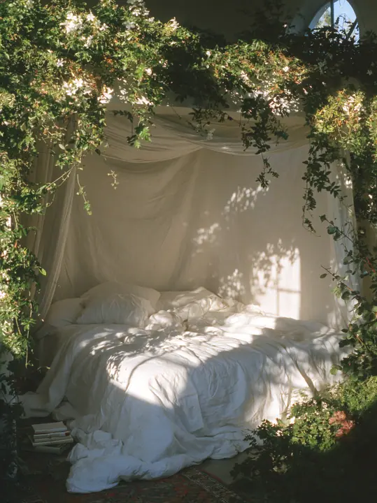 a dreamy bedroom with a linen canopy bed and trailing plants, soft morning light, no text, no letters, no logos