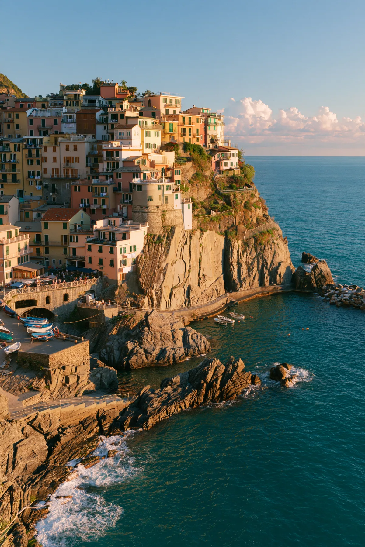 a Mediterranean cliffside village of pastel houses at sunset above a turquoise sea, no text, no letters, no logos