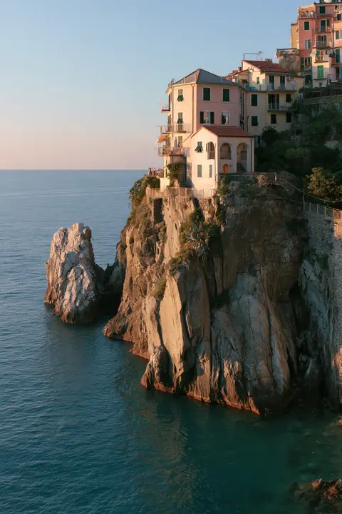 a Mediterranean cliffside village of pastel houses at sunset above a turquoise sea, no text, no letters, no logos