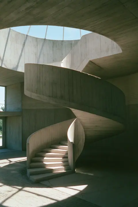 a brutalist concrete spiral staircase under a skylight, soft shadows, no text, no letters, no logos