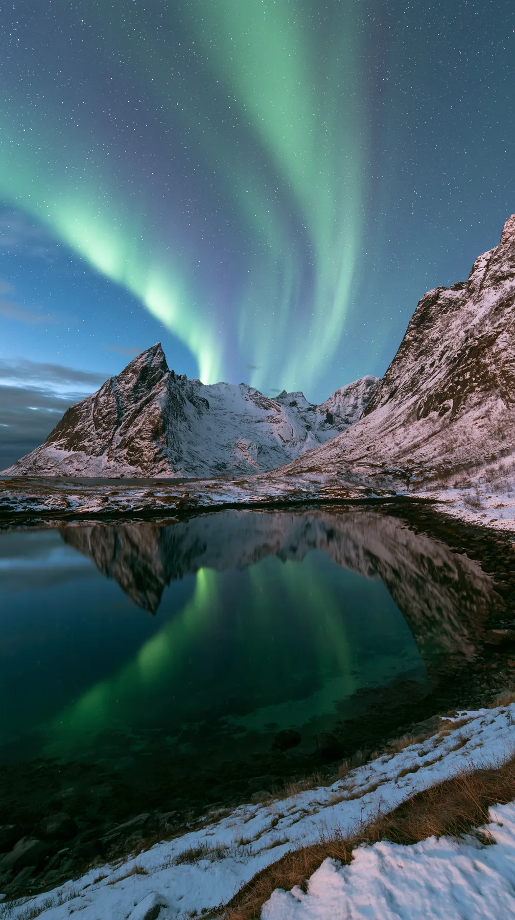 the northern lights rippling green and violet over a snowy mountain lake, no text, no letters, no logos