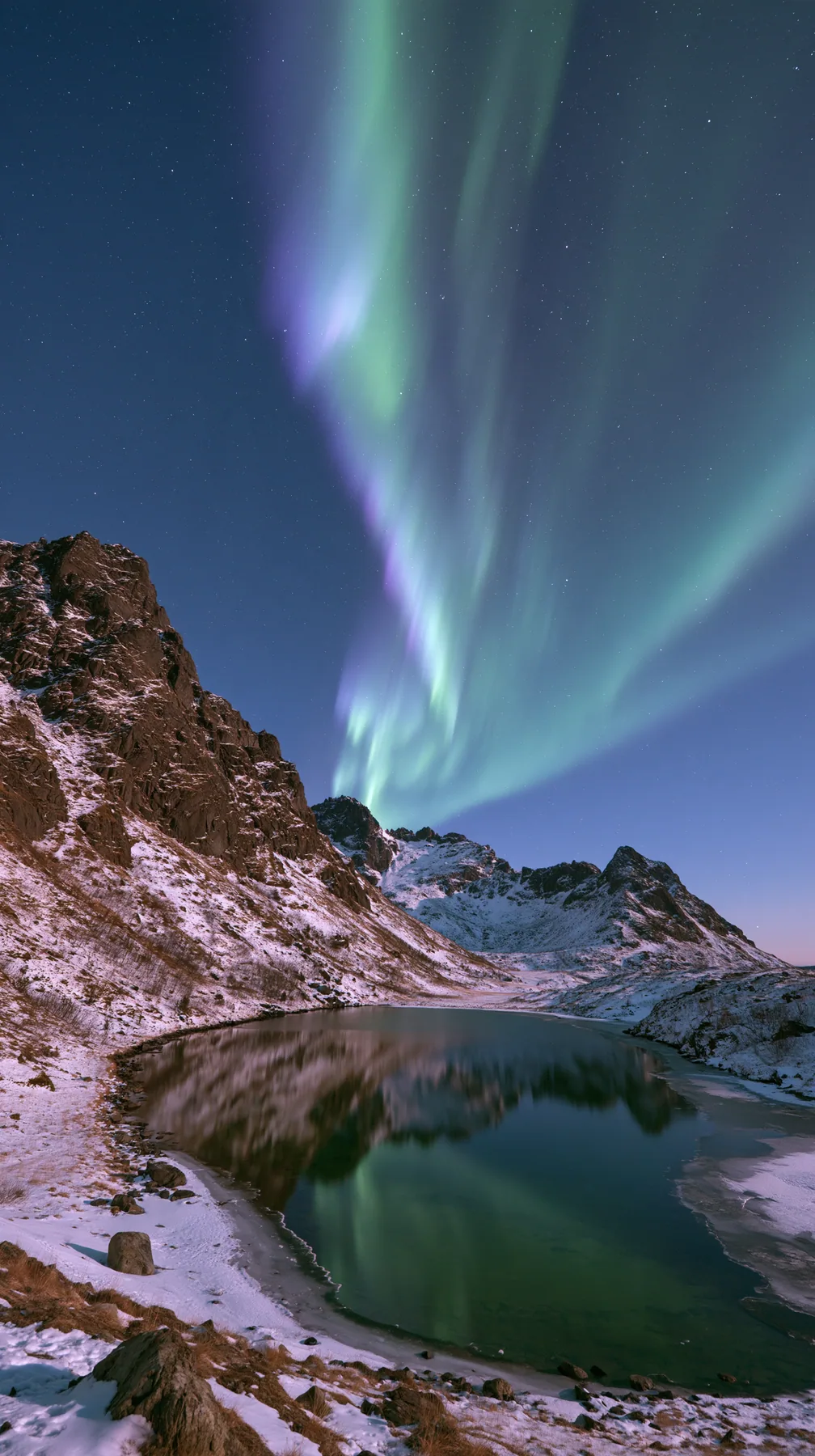 the northern lights rippling green and violet over a snowy mountain lake, no text, no letters, no logos