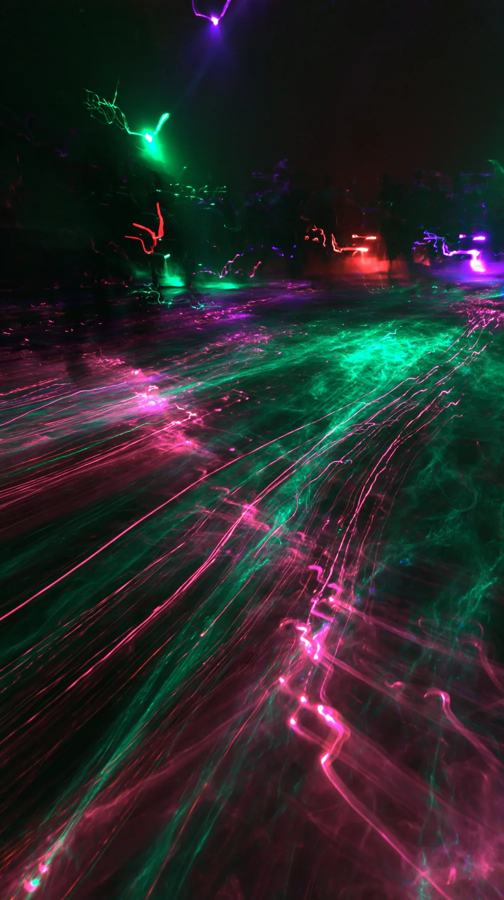 a crowded-looking dance floor reduced to long-exposure light trails of magenta and green, no faces, no text, no letters, no logos