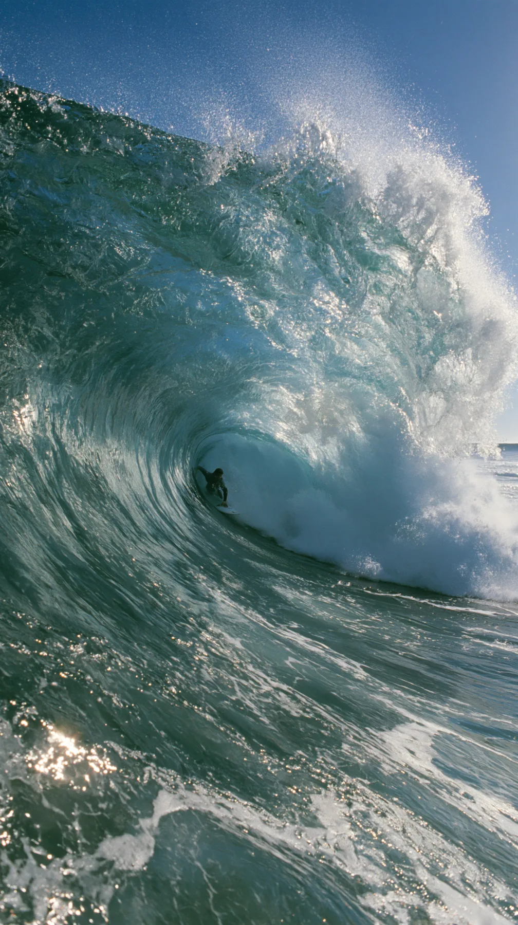 a surfer inside a glassy turquoise barrel wave, sunlit spray, editorial, no text, no letters, no logos