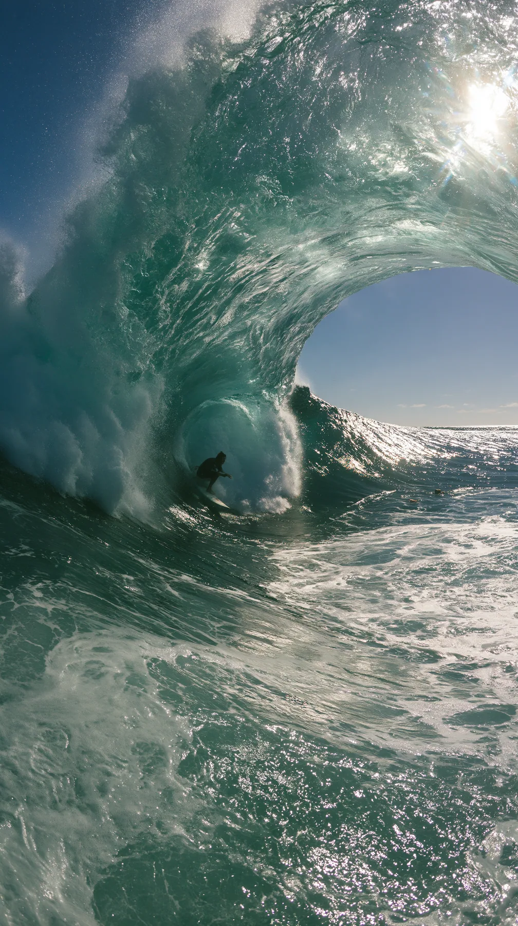 a surfer inside a glassy turquoise barrel wave, sunlit spray, editorial, no text, no letters, no logos