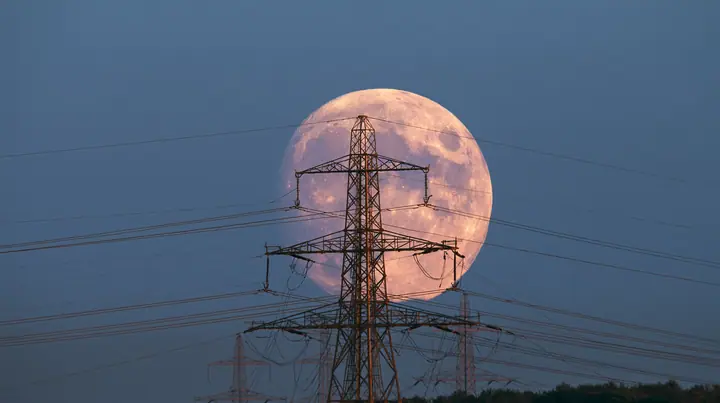 a full moon rising behind a power line at dusk, telephoto, crisp, no text, no letters, no logos
