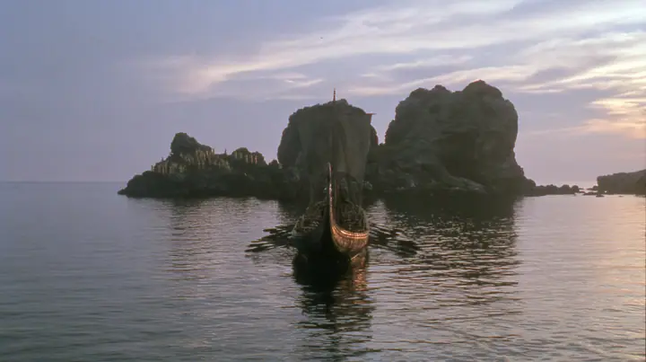 extreme wide shot from behind a long black ancient Greek galley with a single mast, a square sail and two banks of oars on a glassy sea, on the horizon a cluster of black rocks with tiny gold-lit figures of women,…
