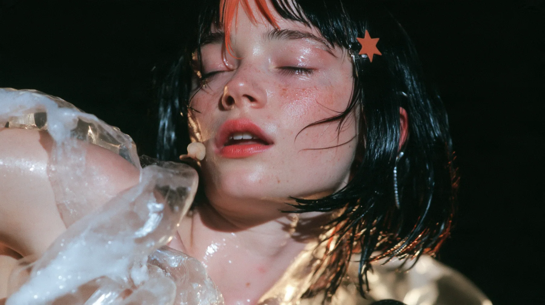 close-up of a Caucasian American woman in her mid-twenties with pale skin and light freckles, a glossy black blunt jaw-length bob with heavy straight bangs and one clay-orange streak through the bangs, a small flat…