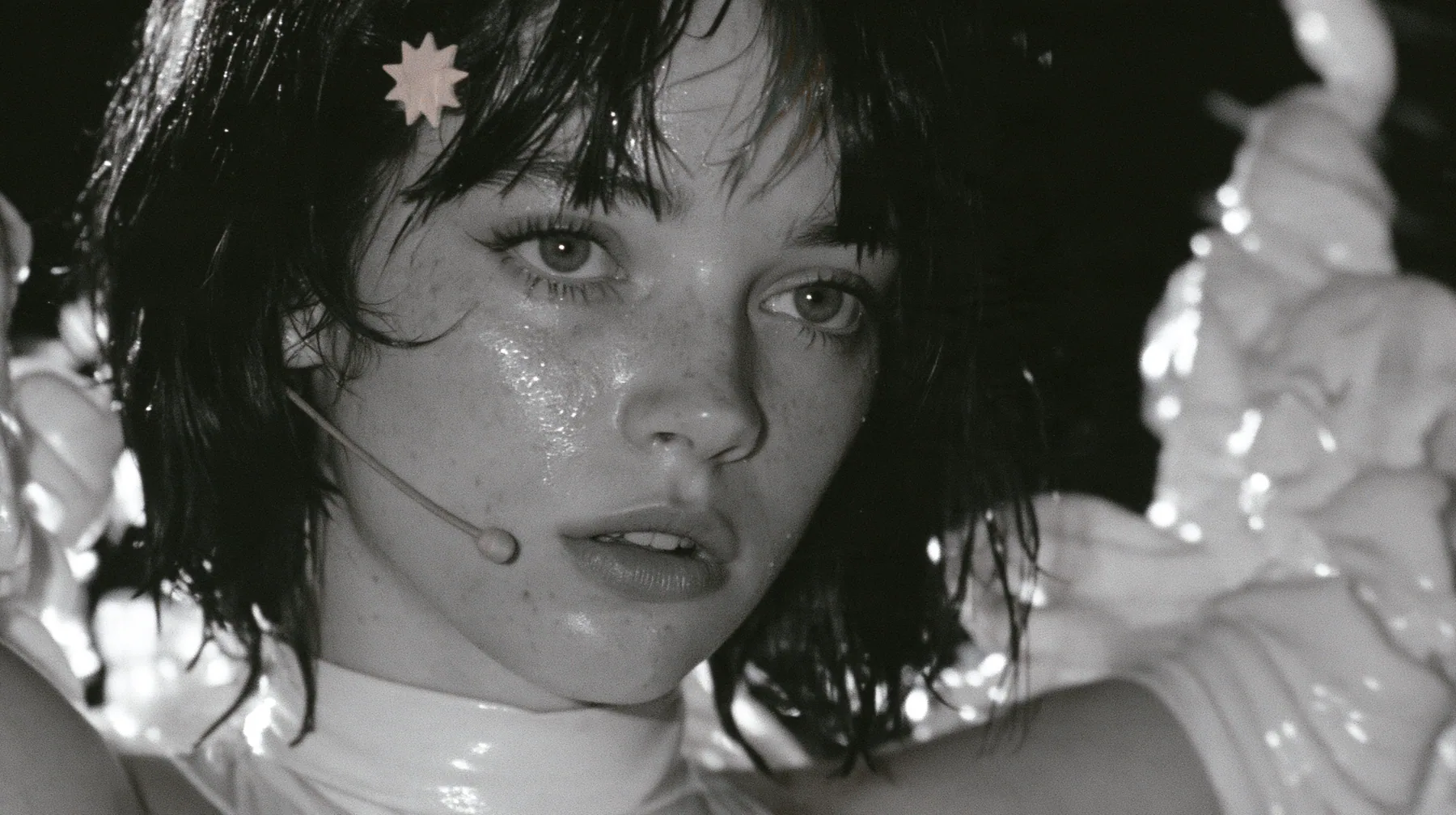 extreme close-up of the lips of a Caucasian American woman in her mid-twenties with pale skin and light freckles, a glossy black blunt jaw-length bob with heavy straight bangs and one clay-orange streak through the…