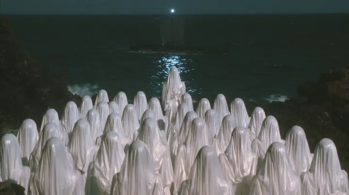 extreme wide shot from behind hundreds of identical bare-headed women with glossy black bobs in white couture gowns standing on black sea rocks with their backs to the camera, looking out to a long black ancient…