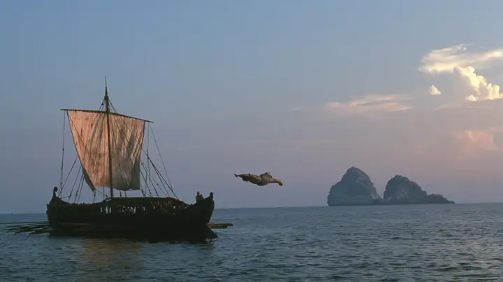 a rower in a linen tunic in a joyous swan dive off the rail of a long black ancient Greek galley with a single mast, a square sail and two banks of oars toward distant glowing rocks, deep blue twilight, the last gold…