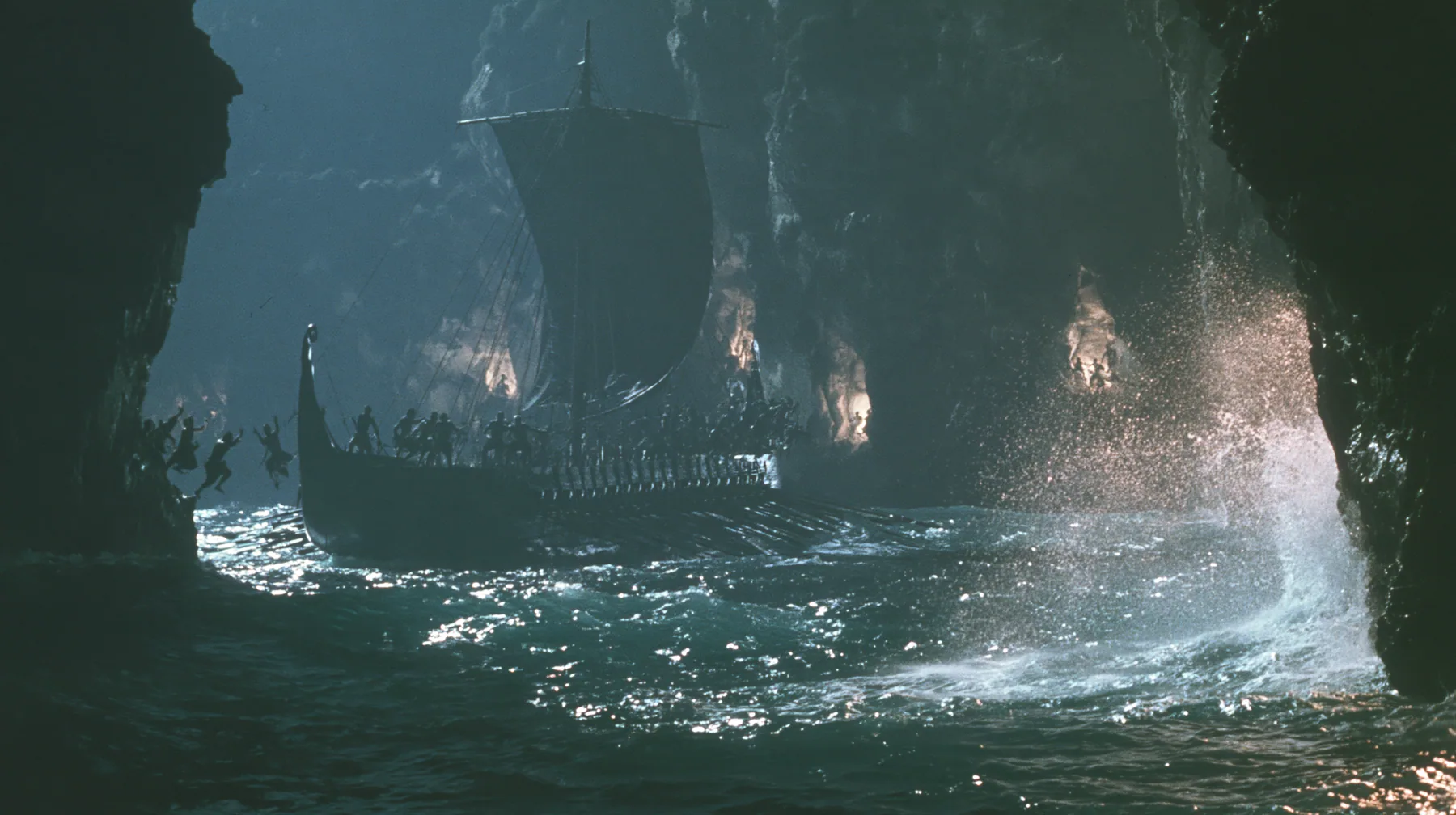 silhouettes of men leaping from both rails of a long black ancient Greek galley with a single mast, a square sail and two banks of oars into a narrow strait, cliffs of glowing alcoves behind them, night, moonlight on…