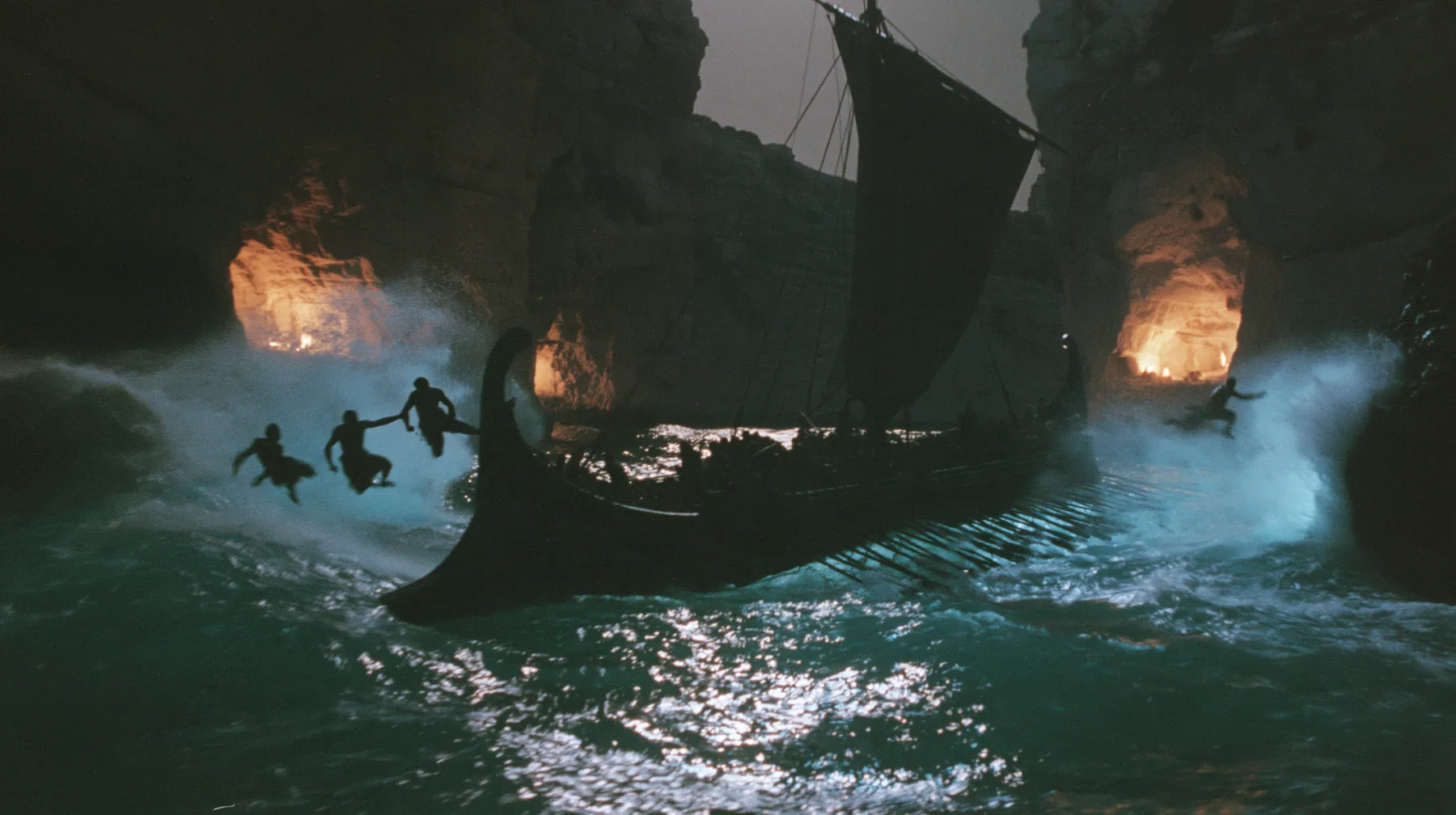 silhouettes of men leaping from both rails of a long black ancient Greek galley with a single mast, a square sail and two banks of oars into a narrow strait, cliffs of glowing alcoves behind them, night, moonlight on…
