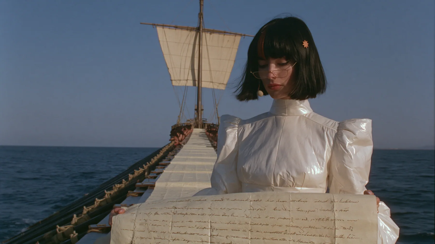 wide shot along the deck of a long black ancient Greek galley with a single mast, a square sail and two banks of oars, a long papyrus scroll covered in handwritten lines unrolled down the length of the deck between…