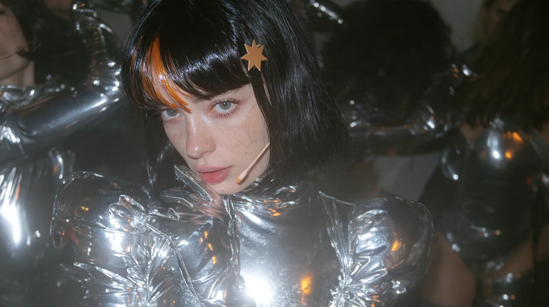 full-length shot of a Caucasian American woman in her mid-twenties with pale skin and light freckles, a glossy black blunt jaw-length bob with heavy straight bangs and one clay-orange streak through the bangs, a…