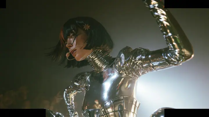 full-length shot of a Caucasian American woman in her mid-twenties with pale skin and light freckles, a glossy black blunt jaw-length bob with heavy straight bangs and one clay-orange streak through the bangs, a…