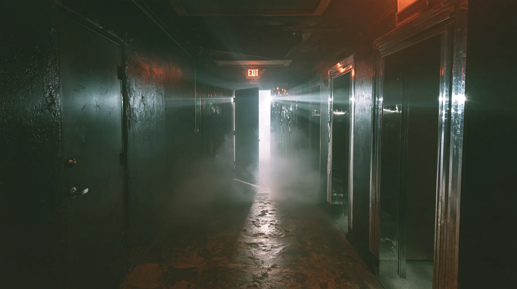 a bathroom door swinging shut at the end of a dark warehouse corridor, strobe spill on the walls, a San Francisco warehouse rave, fog, white strobe, chrome reflections, deep black, flash photography, no text, no…