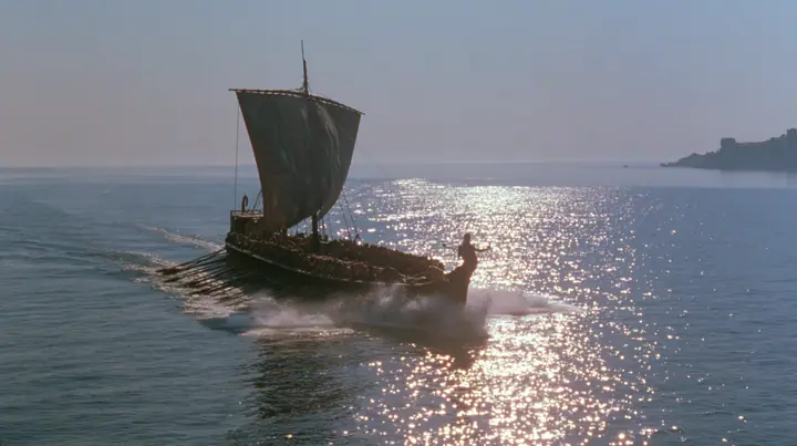 wide low shot of a long black ancient Greek galley with a single mast, a square sail and two banks of oars racing across a sparkling morning sea, oars driving in unison, spray flying, a man tied to the mast, clear…