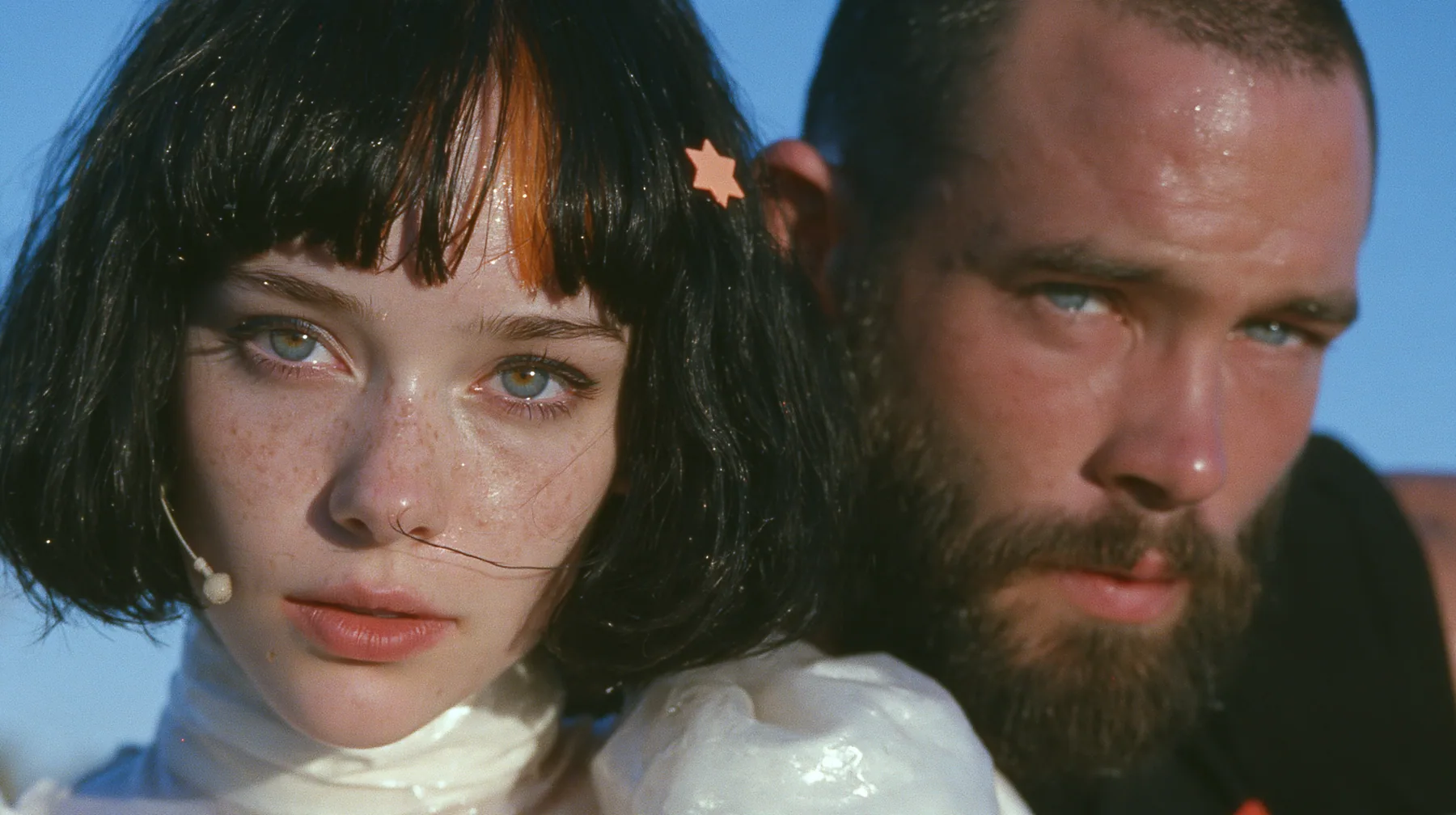 extreme close-up of a Caucasian American woman in her mid-twenties with pale skin and light freckles, a glossy black blunt jaw-length bob with heavy straight bangs and one clay-orange streak through the bangs, a…