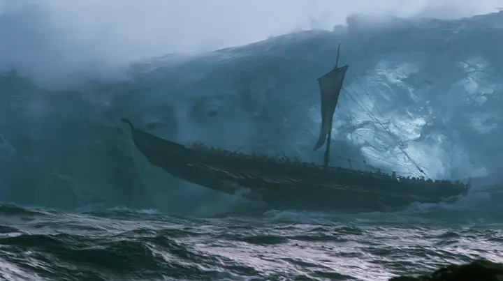 wide shot of a long black ancient Greek galley with a single mast, a square sail and two banks of oars lifted high on a rising mountain of water, and through the translucent face of the swell a colossal pale woman's…