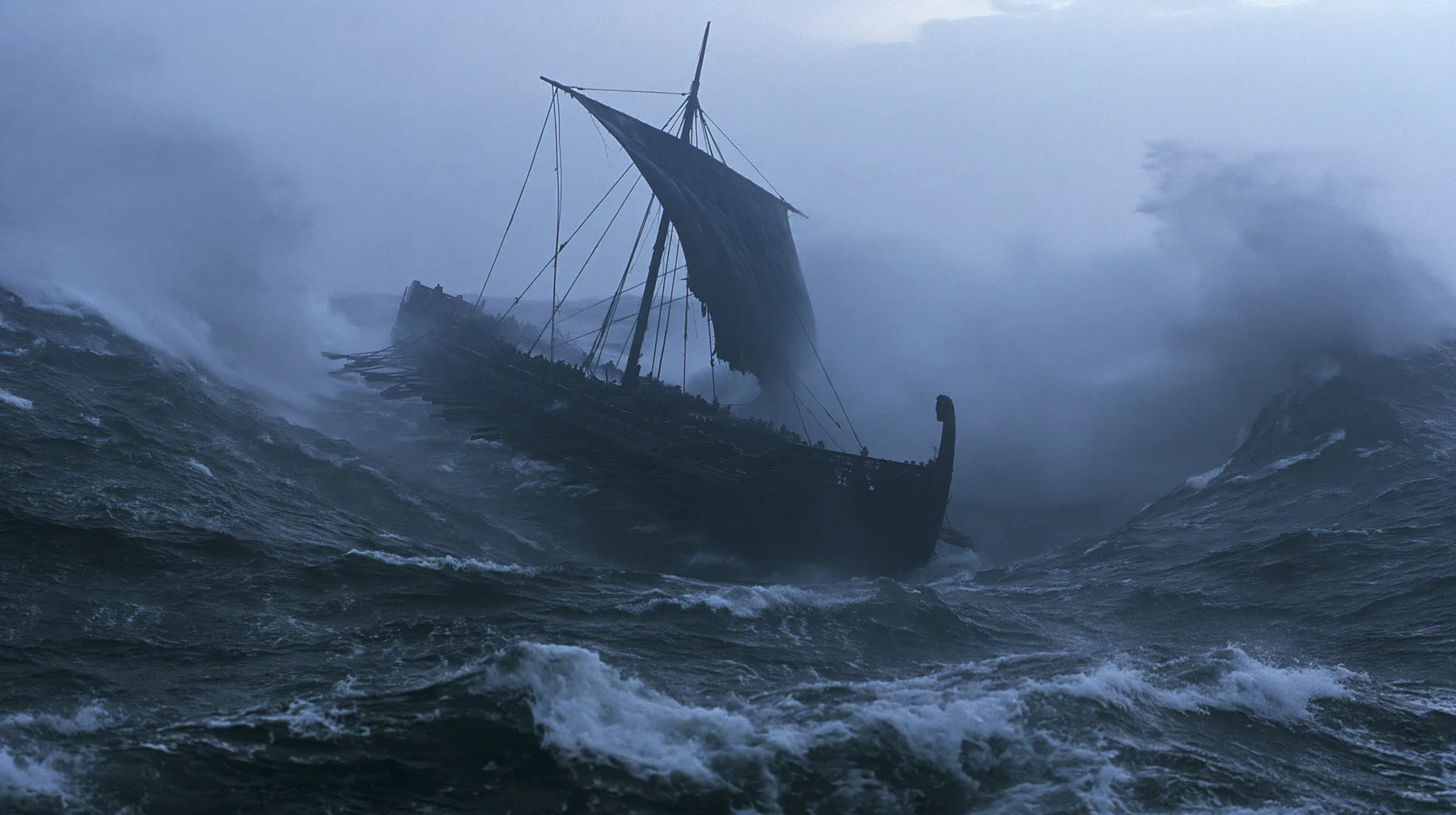 wide shot of a long black ancient Greek galley with a single mast, a square sail and two banks of oars dropping into an enormous trough as the sea falls away around it, walls of dark water on both sides, grey first…