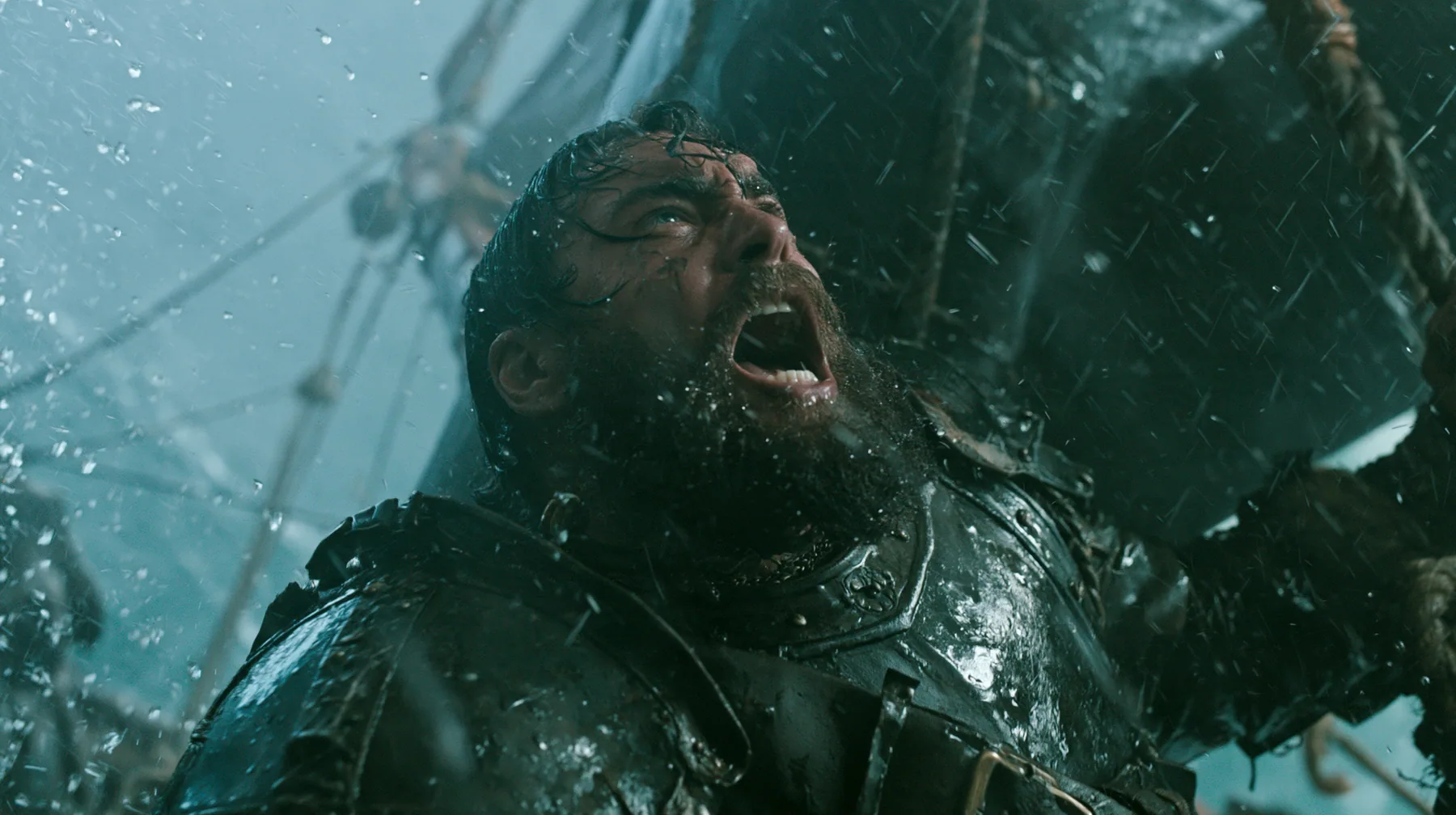 a bearded man in battered leather armour lashed to the mast of a black ship in a storm, screaming at the sky, large-format film still, practical storm, rain and spray, teal and black, no text, no letters, no logos