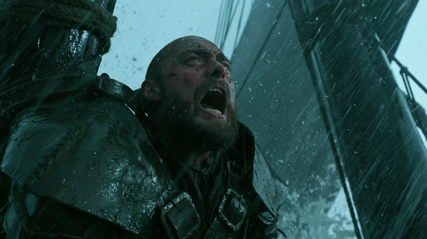 a bearded man in battered leather armour lashed to the mast of a black ship in a storm, screaming at the sky, large-format film still, practical storm, rain and spray, teal and black, no text, no letters, no logos