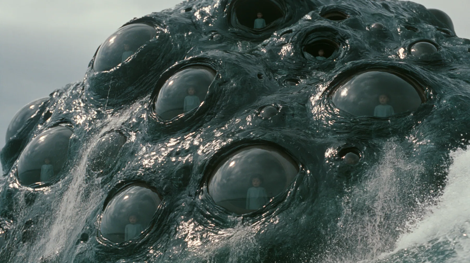 extreme close-up of the wet black-green hide of a colossal sea monster rising out of the sea, the hide studded with dozens of large glossy human eyes of different sizes, some wide open and some half-closed, each eye…