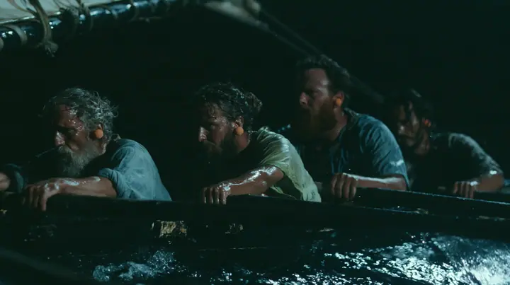 medium shot along a rowing bench of a long black ancient Greek galley with a single mast, a square sail and two banks of oars at night, four oarsmen of different ages and builds pulling their oars together, a…