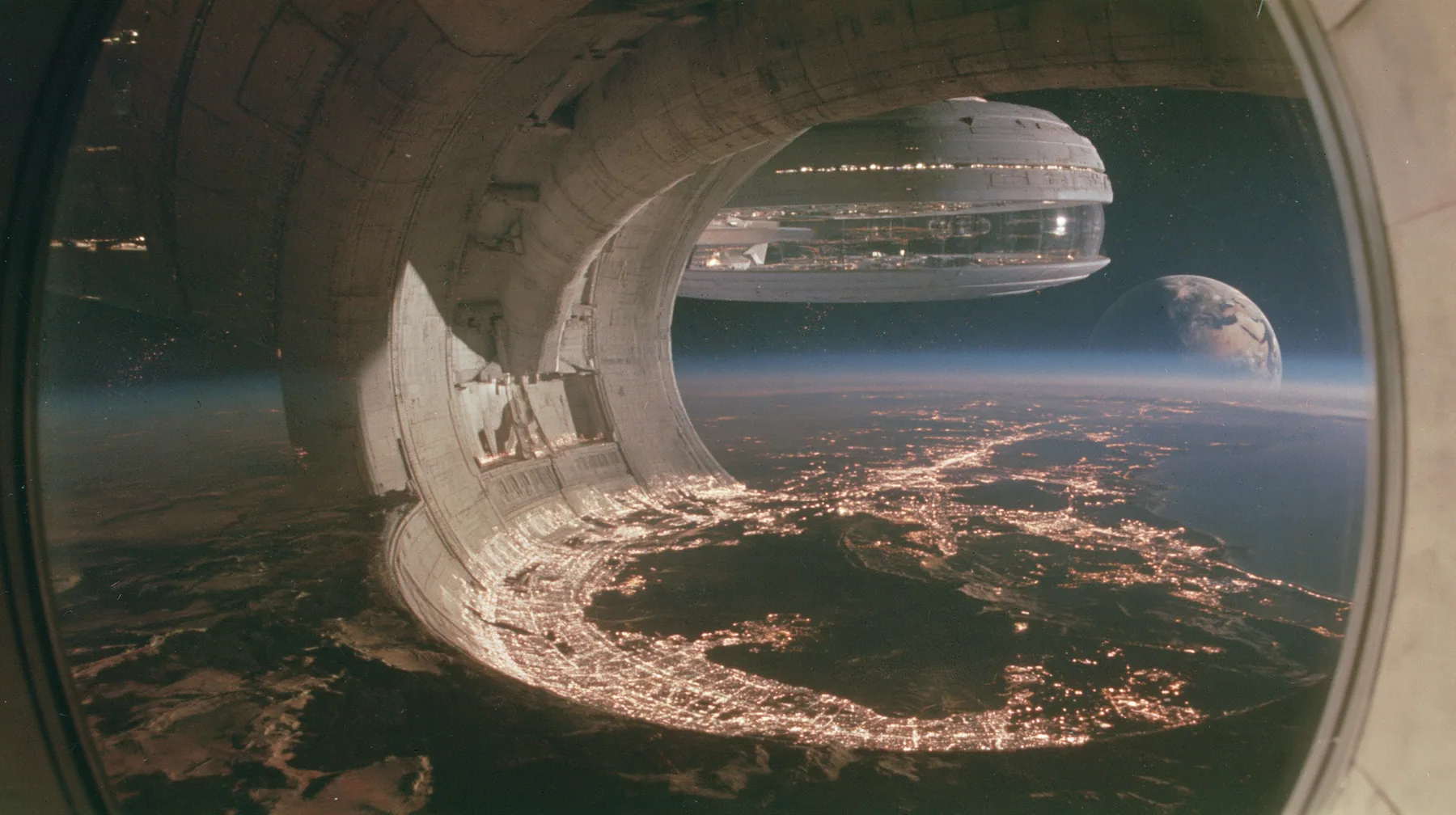 A 35 mm photograph from inside a space colony at night looking out through a vast circular end-cap window: the lit white towns curve around the dark land, and through the window the white capsule-shaped colony's…