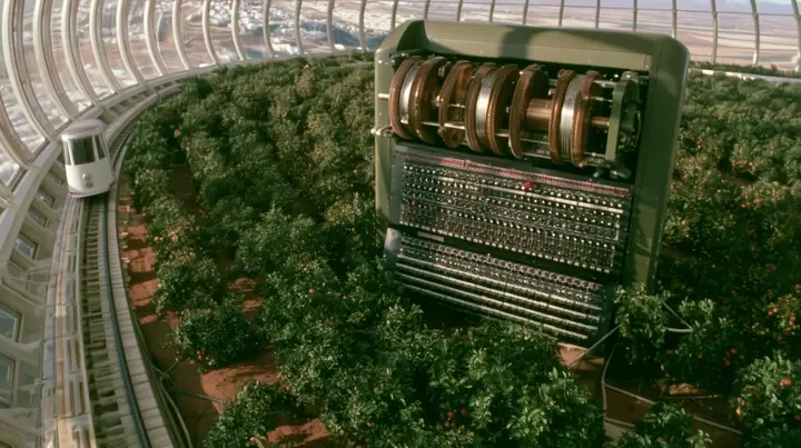 Make this the same photograph with nobody in it: remove the woman and continue the scene behind her where she stood. Keep everything else exactly: the giant Enigma machine, the orchard and the white tram on its rail,…