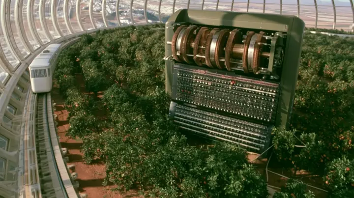 Make this the same photograph with nobody in it: remove the woman and continue the scene behind her where she stood. Keep everything else exactly: the giant Enigma machine, the orchard and the white tram on its rail,…