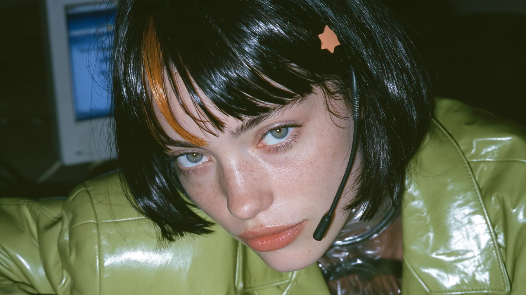 Y2K high fashion editorial, a 2001 couture magazine story: medium close-up of a Caucasian American woman in her mid-twenties with pale skin and light freckles, a glossy black blunt jaw-length bob with heavy straight…