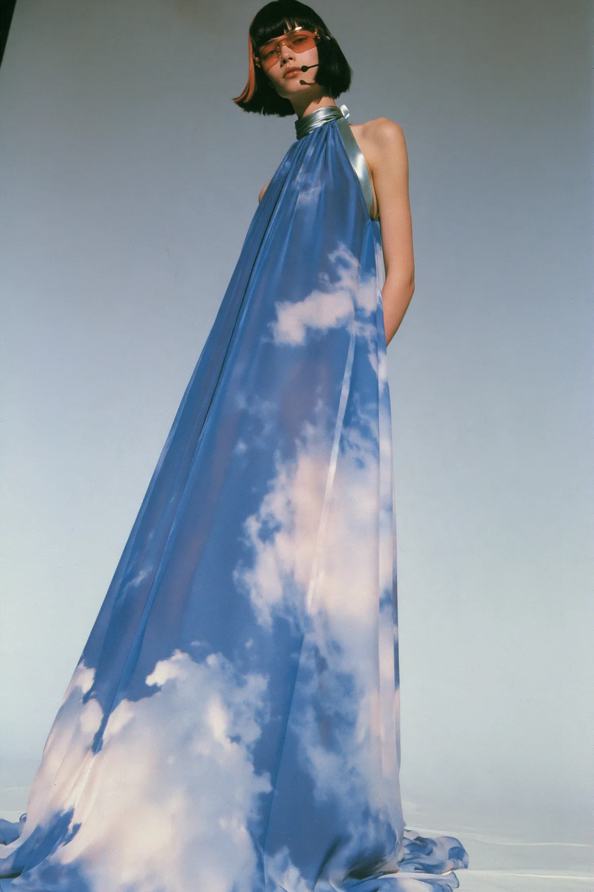 Y2K high fashion editorial, a 2001 couture magazine story: full-length shot, head to toe with the feet in frame, of a young Caucasian American woman with pale skin and a glossy black blunt bob with heavy straight…
