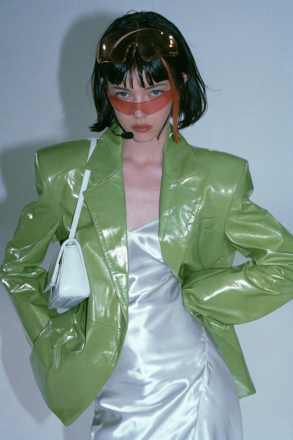 Y2K high fashion editorial, a 2001 couture magazine story: full-length shot, head to toe with the feet in frame, of a young Caucasian American woman with pale skin and a glossy black blunt bob with heavy straight…