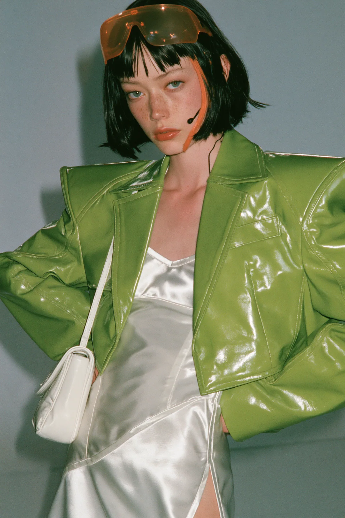 Y2K high fashion editorial, a 2001 couture magazine story: full-length shot, head to toe with the feet in frame, of a young Caucasian American woman with pale skin and a glossy black blunt bob with heavy straight…