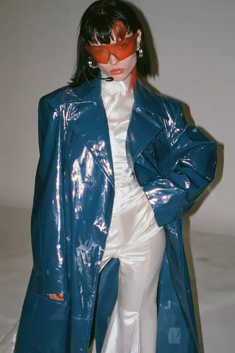 Y2K high fashion editorial, a 2001 couture magazine story: full-length shot, head to toe with the feet in frame, of a young Caucasian American woman with pale skin and a glossy black blunt bob with heavy straight…