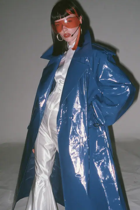 Y2K high fashion editorial, a 2001 couture magazine story: full-length shot, head to toe with the feet in frame, of a young Caucasian American woman with pale skin and a glossy black blunt bob with heavy straight…