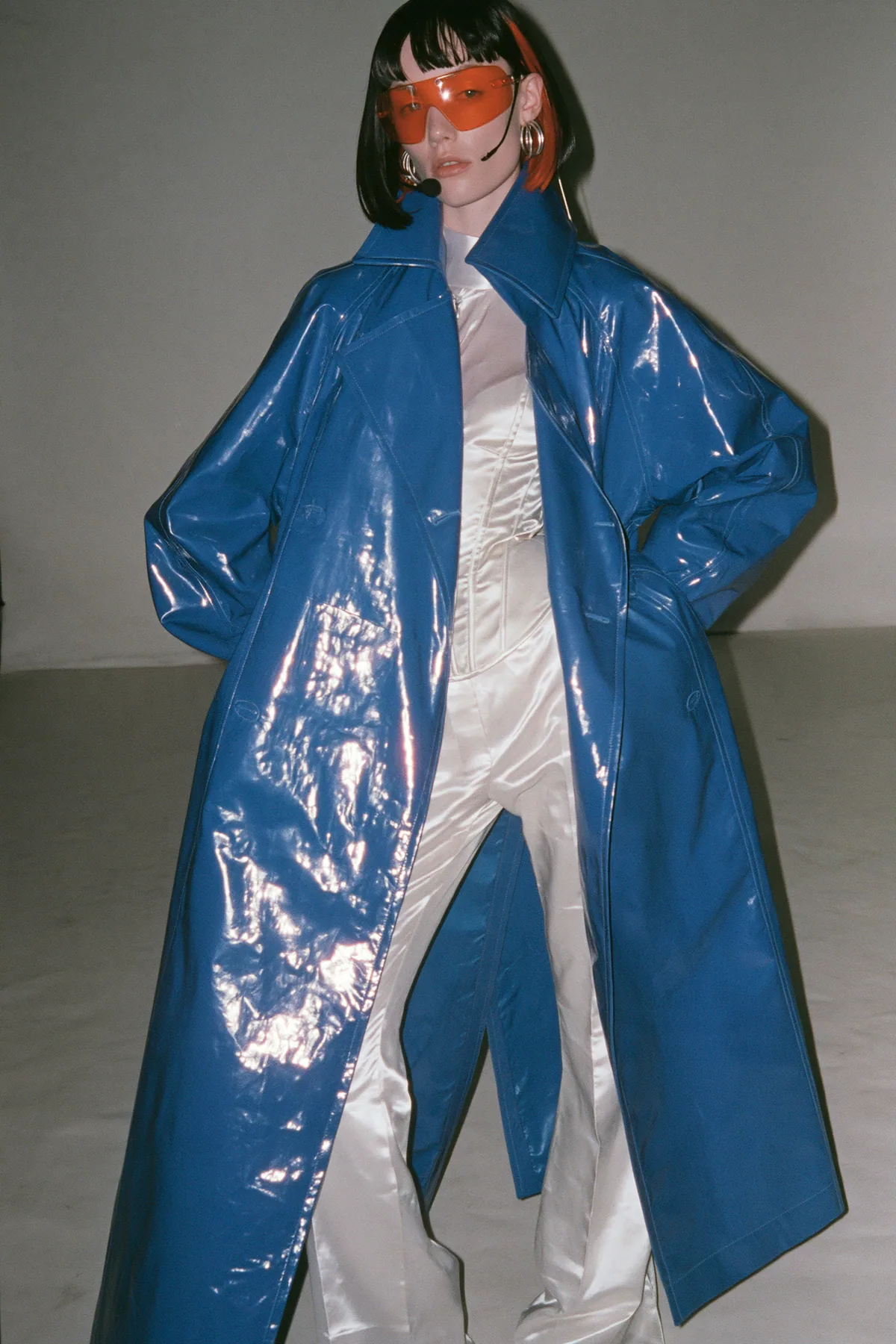 Y2K high fashion editorial, a 2001 couture magazine story: full-length shot, head to toe with the feet in frame, of a young Caucasian American woman with pale skin and a glossy black blunt bob with heavy straight…