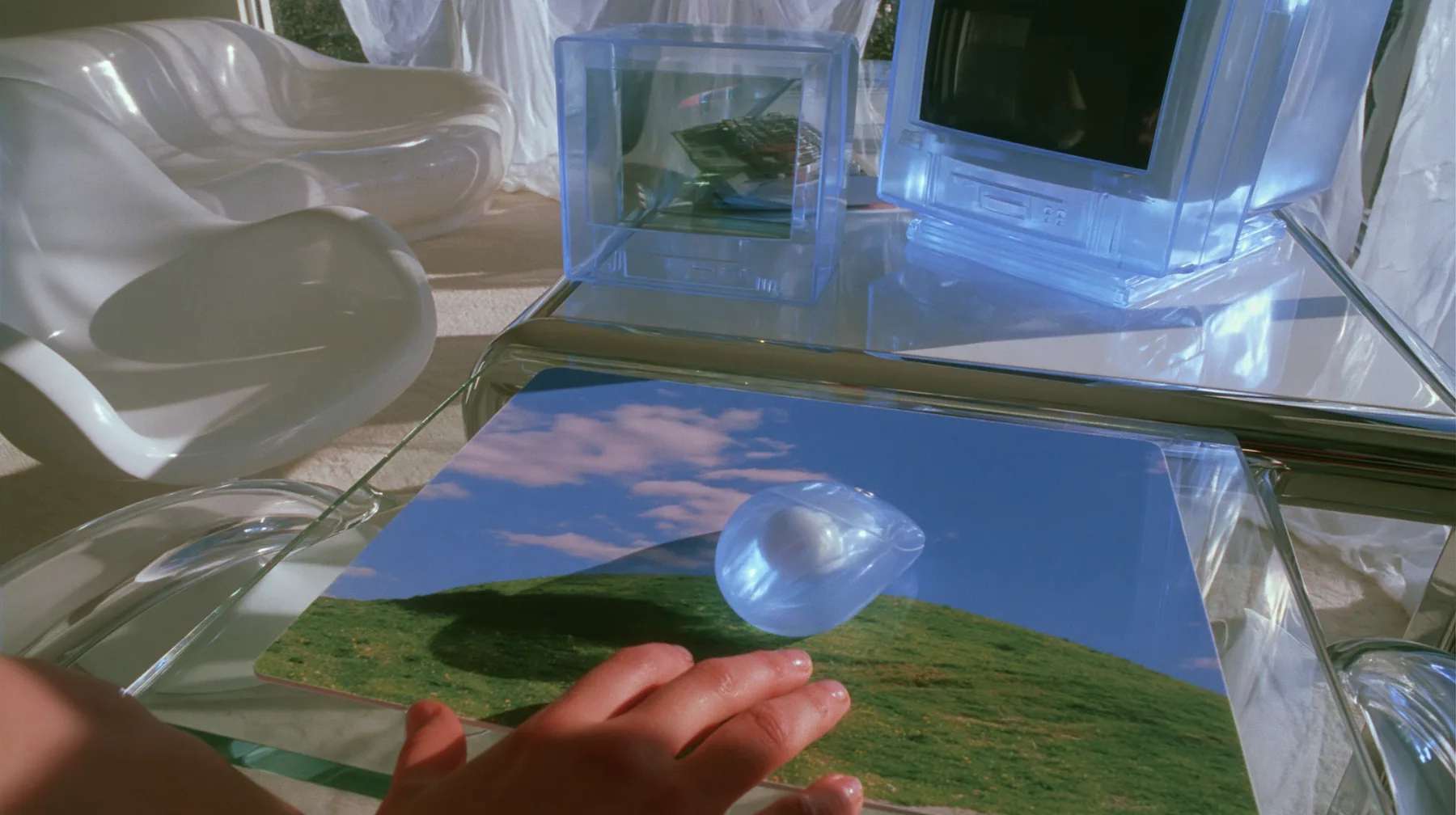 Y2K high fashion editorial photograph, 2001: first-person view from a chair at a 2001 high-fashion minimalist white loft apartment with molded white plastic furniture, a white lacquer desk, chrome and translucent…