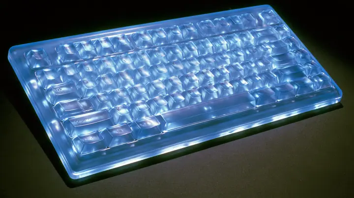 Y2K high fashion editorial photograph, 2001: a luxury product macro of a translucent ice-blue keyboard from 2001, its keys glowing softly, shallow depth of field, no text, no letters, no logos