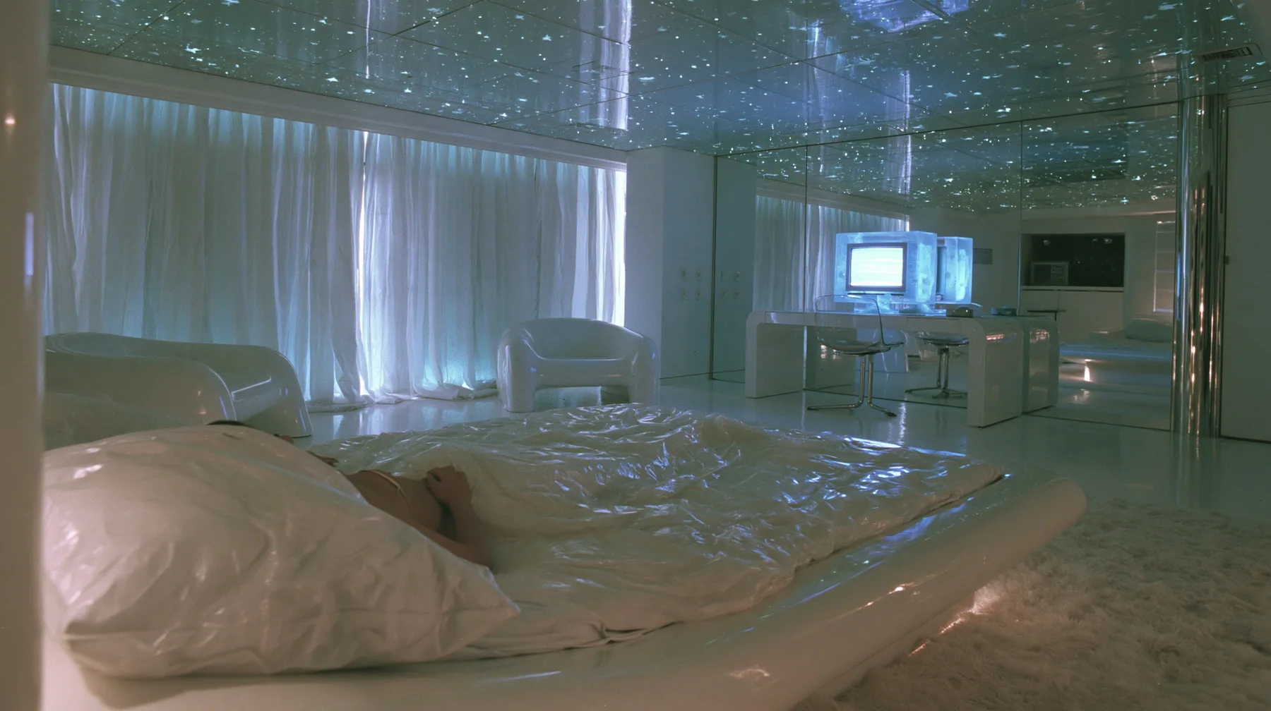 Y2K high fashion editorial photograph, 2001: first-person view from the pillow of a white low bed in a 2001 high-fashion minimalist white loft apartment with molded white plastic furniture, a white lacquer desk,…