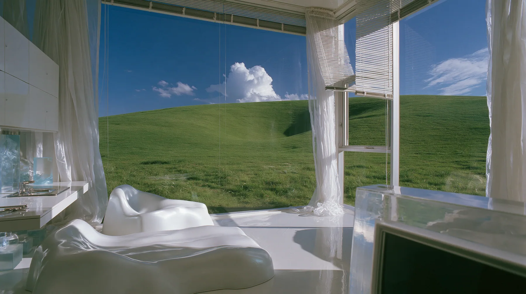 Y2K high fashion editorial photograph, 2001: a 2001 high-fashion minimalist white loft apartment with molded white plastic furniture, a white lacquer desk, chrome and translucent ice-blue plastics, sheer white…