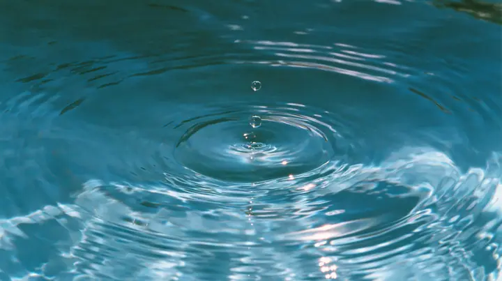 Y2K high fashion editorial photograph, 2001: a luxury beauty-campaign macro of a single drop rippling in calm turquoise water, glossy concentric rings, medium-format, no text, no letters, no logos