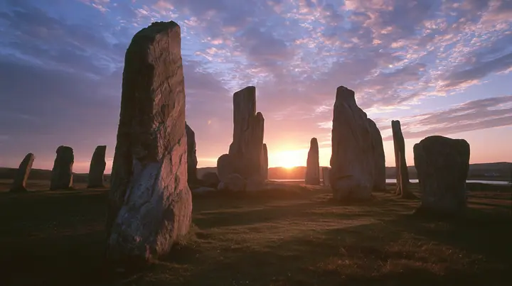Y2K high fashion editorial photograph, 2001: a luxury campaign landscape of ancient standing stones silhouetted against a glowing violet and amber sunset, medium-format slide film, no text, no letters, no logos