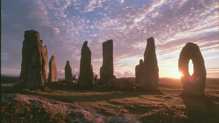 Y2K high fashion editorial photograph, 2001: a luxury campaign landscape of ancient standing stones silhouetted against a glowing violet and amber sunset, medium-format slide film, no text, no letters, no logos