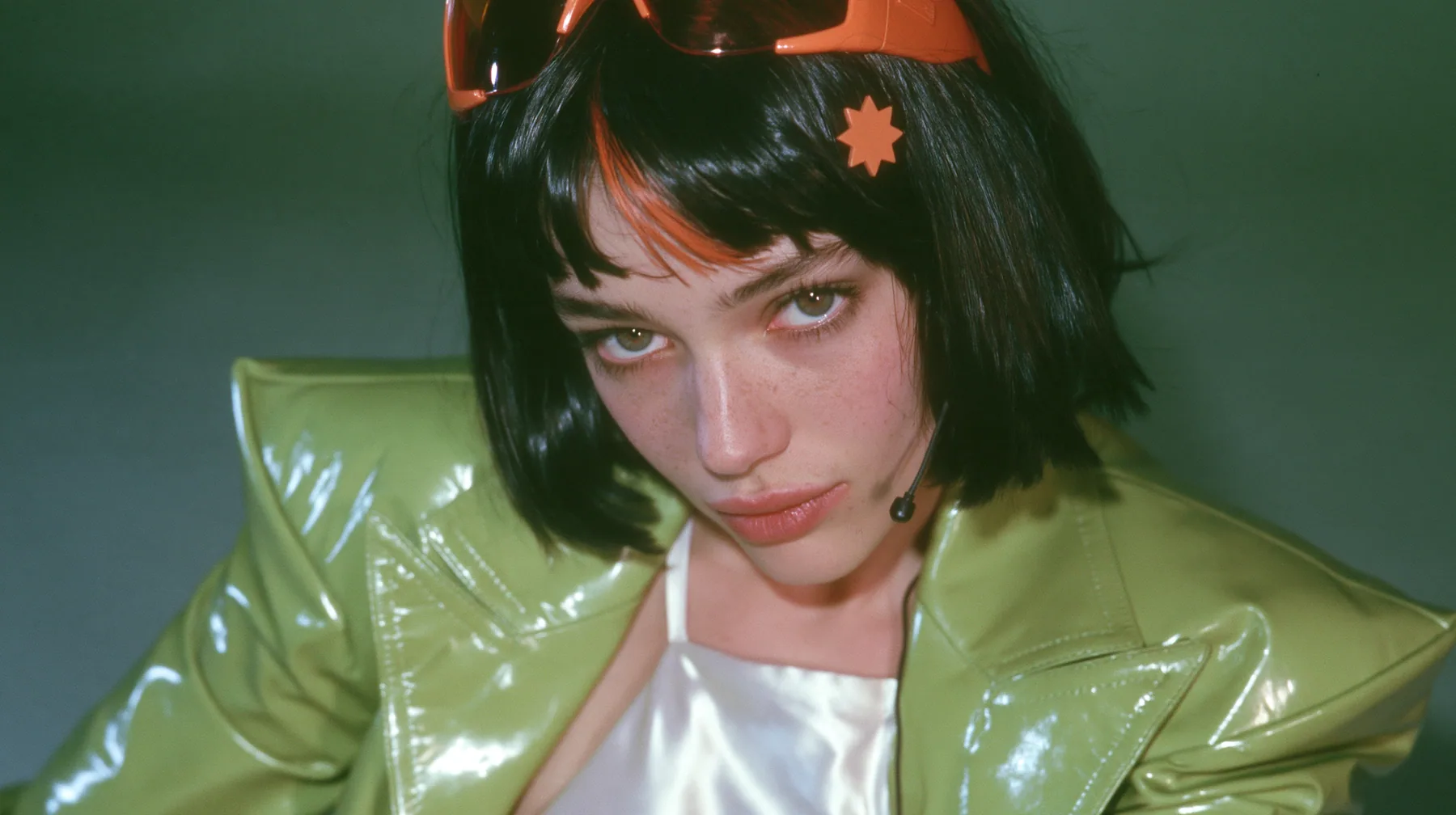 Y2K high fashion editorial, 2001: a medium close-up of a Caucasian American woman in her mid-twenties with pale skin and light freckles, a glossy black blunt jaw-length bob with heavy straight bangs and one…