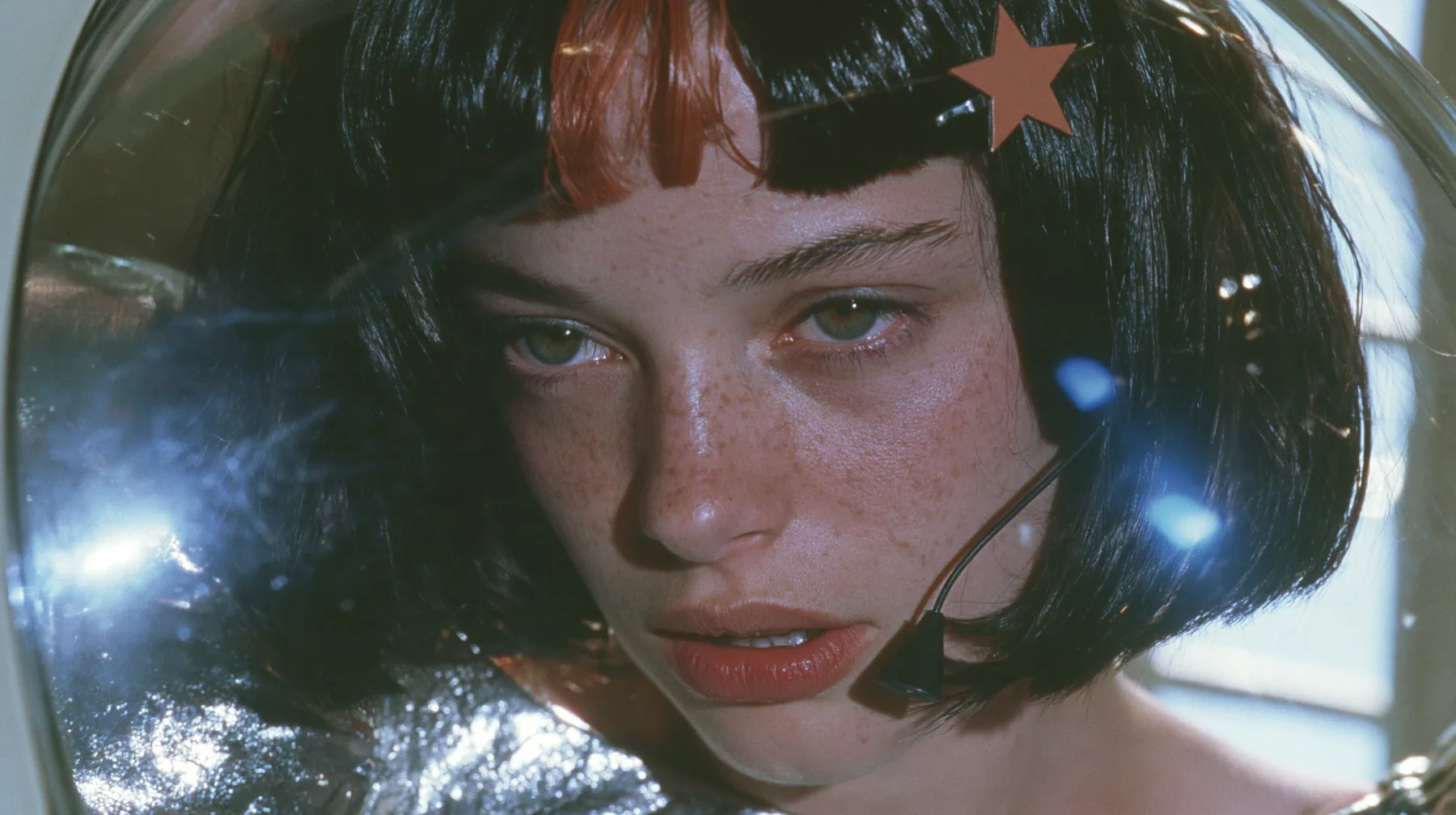 Y2K high fashion editorial, a 2001 couture magazine story: a close-up of a Caucasian American woman in her mid-twenties with pale skin and light freckles, a glossy black blunt jaw-length bob with heavy straight bangs…