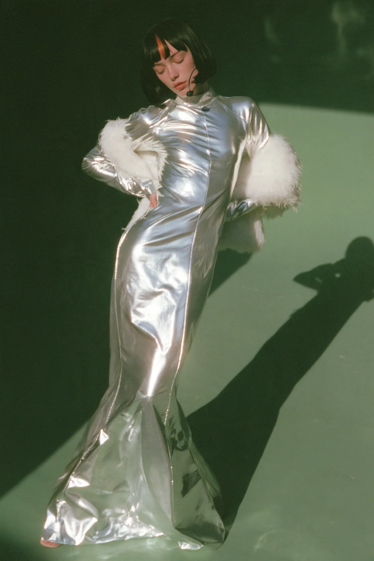 Y2K high fashion editorial, a 2001 couture magazine story: full-length shot, head to toe with the feet in frame, of a young Caucasian American woman with pale skin and a glossy black blunt bob with heavy straight…